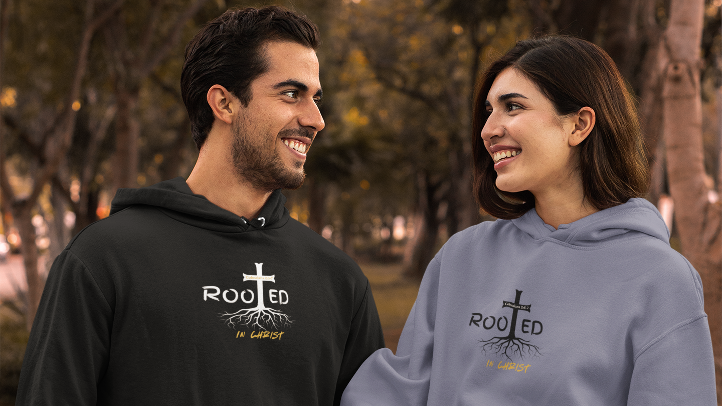 Two people wearing hoodies with a 'Rooted' design in an outdoor setting.